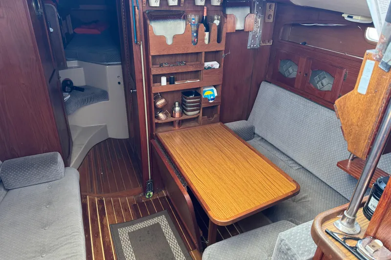Interior of a 1988 Gulf Pilot House boat with cozy seating and wooden table.