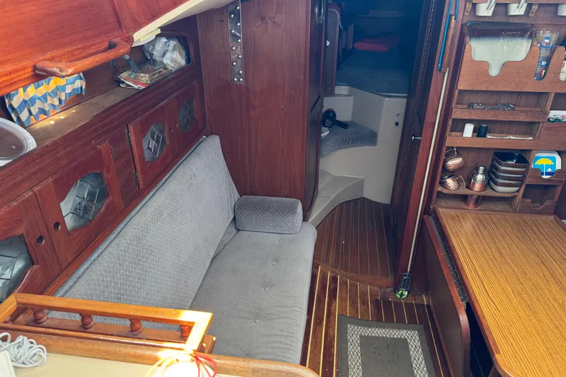 Interior of a 1988 Gulf Pilot House boat with wooden furnishings and cozy seating.