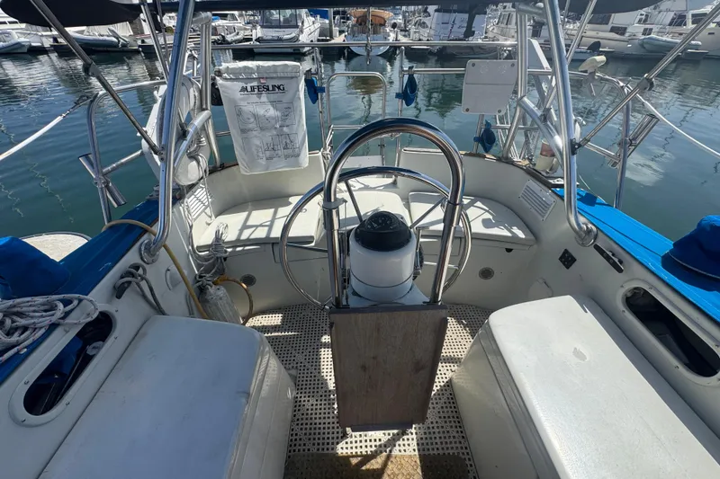 Cockpit of a 1988 Gulf Pilot House boat with steering wheel and marina view.