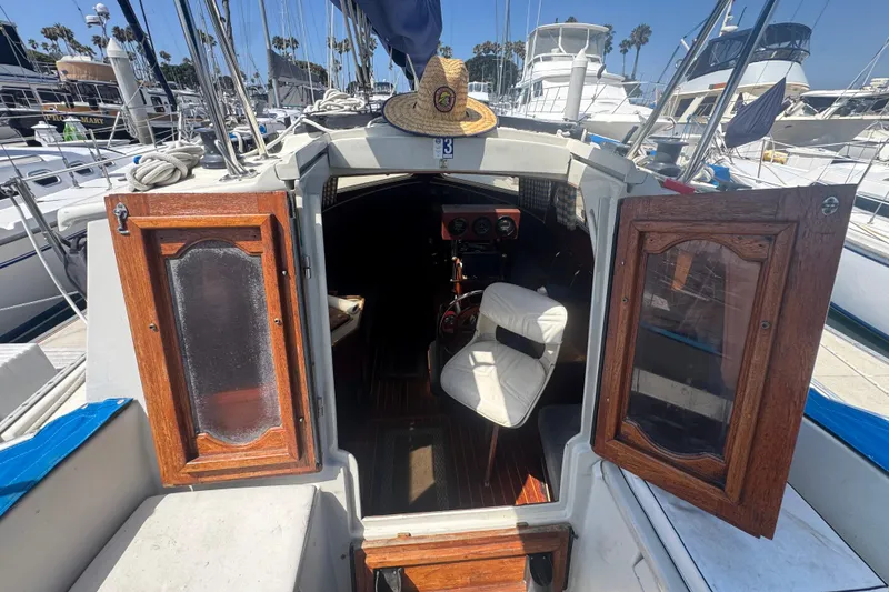 1988 Gulf Pilot House boat interior with open wooden doors and a hat on top.