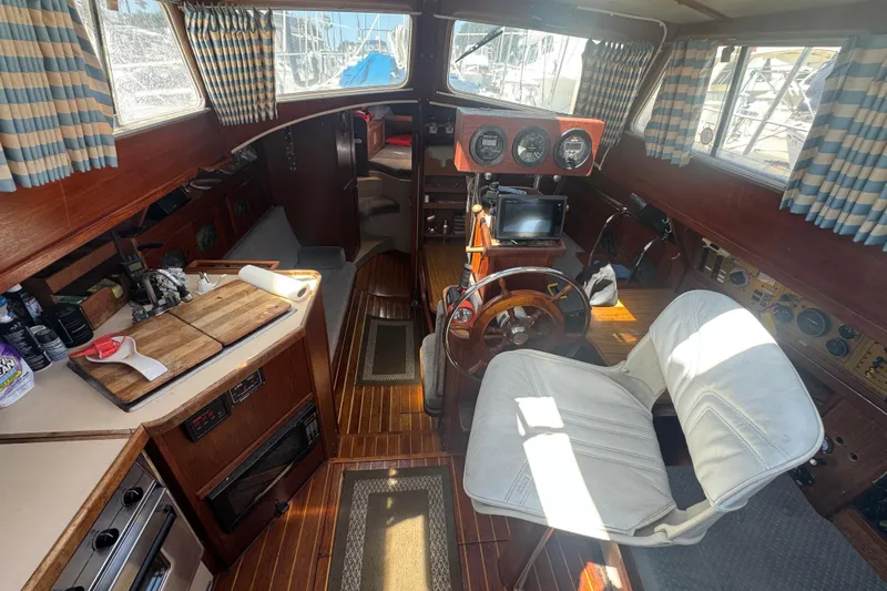 1988 Gulf Pilot House interior with wooden helm, gauges, and nautical decor.