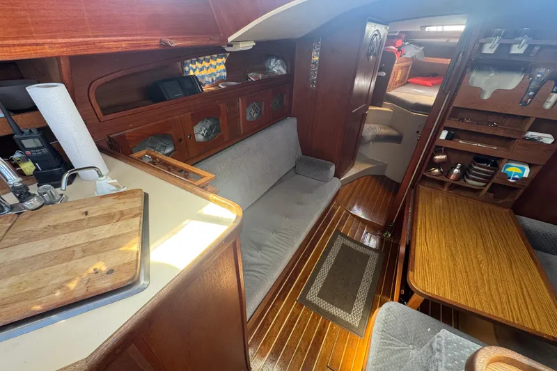 Interior of a 1988 Gulf Pilot House boat with wooden furnishings and cozy seating.