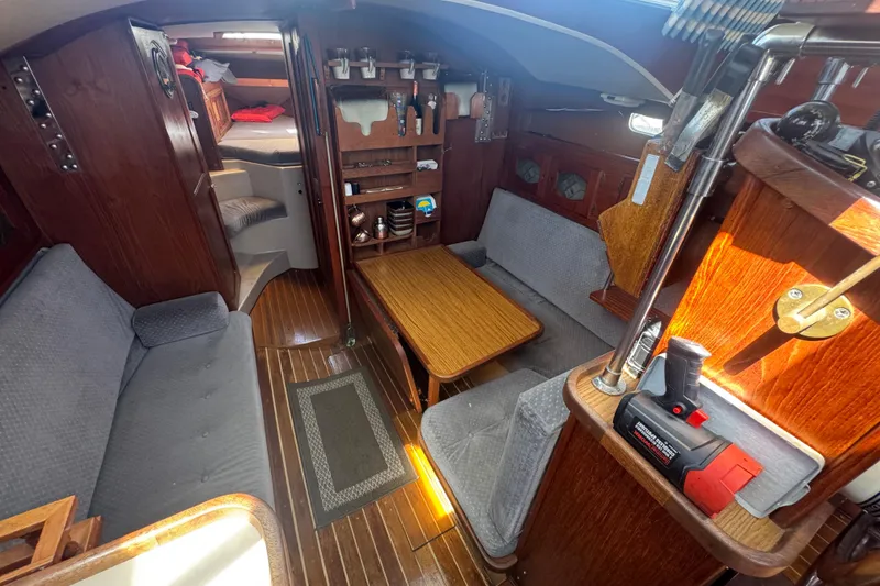 Interior of a 1988 Gulf Pilot House boat with wooden furnishings and cozy seating.