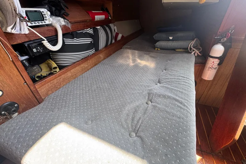 Interior of a 1988 Gulf Pilot House boat with a cushioned berth and storage.