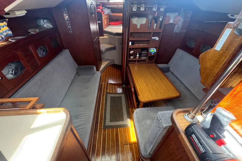 Interior of a 1988 Gulf Pilot House boat with wooden furnishings and cozy seating.