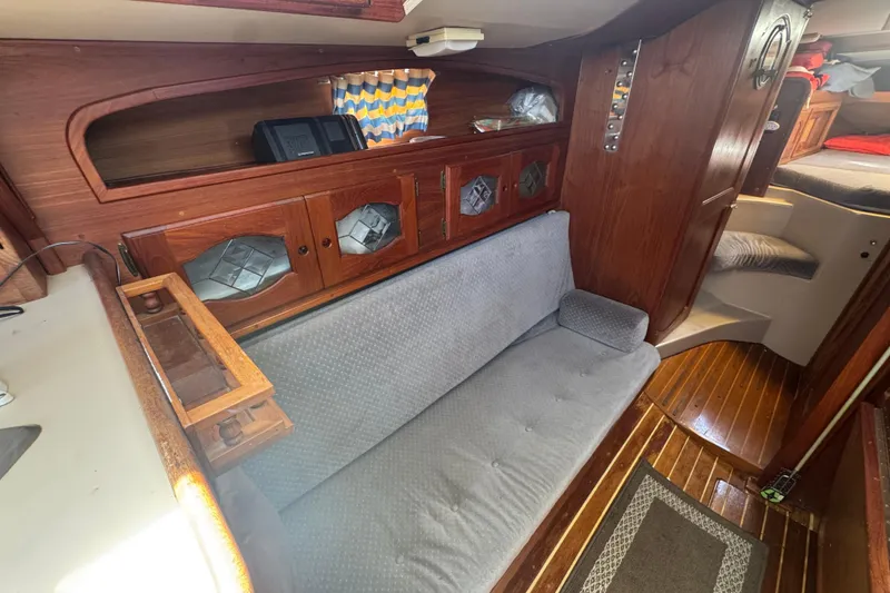 Interior of a 1988 Gulf Pilot House boat with wooden cabinetry and cushioned seating.
