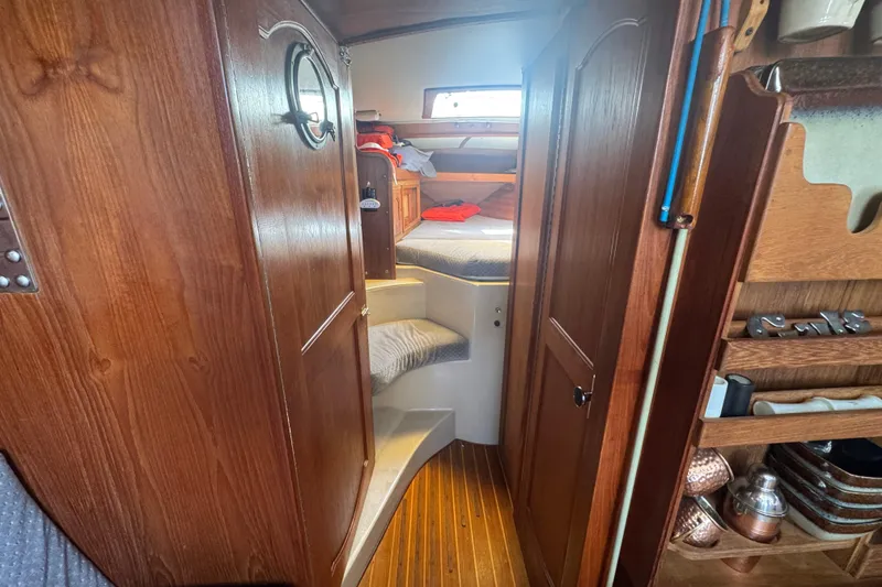 Interior of 1988 Gulf Pilot House boat with wooden cabinetry and cozy sleeping area.