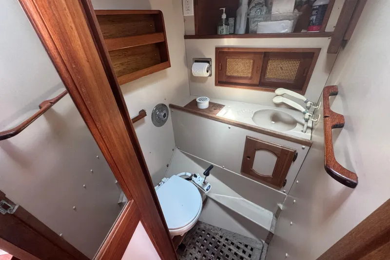 1988 Gulf Pilot House bathroom with wooden accents, sink, and toilet.