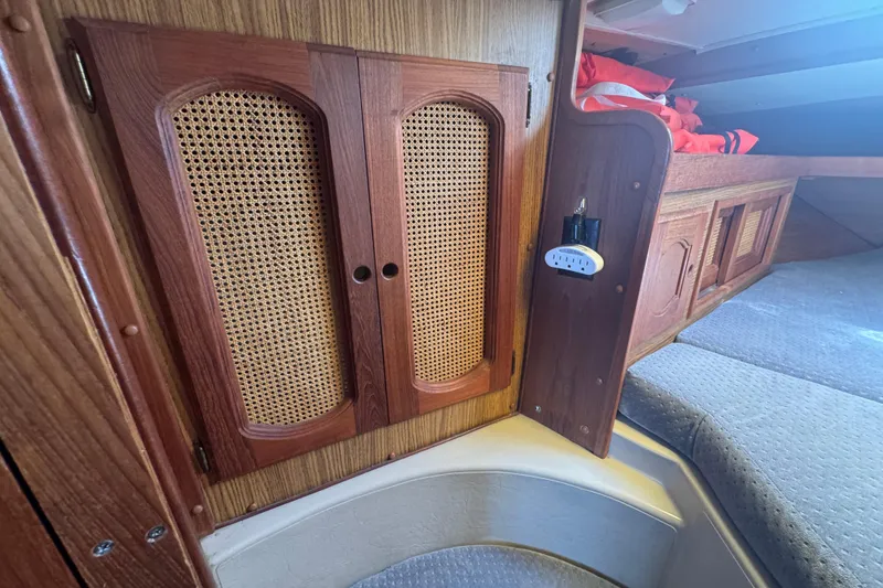 1988 Gulf Pilot House interior with wooden cabinetry and woven paneling.