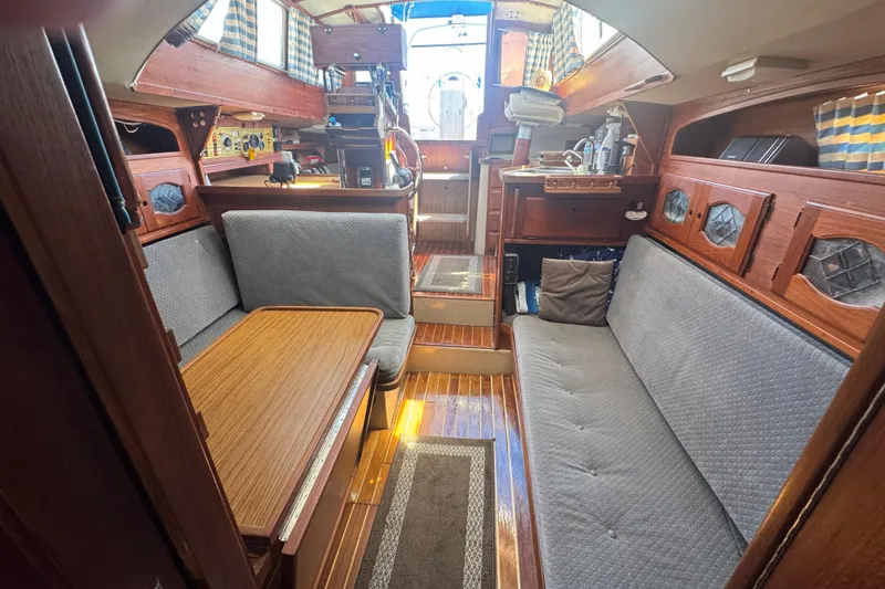 Cozy 1988 Gulf Pilot House interior with wooden furnishings and seating area.
