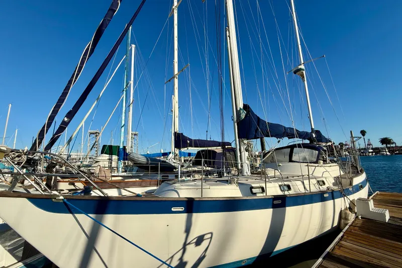 1981 Mariner Mayflower sailboat docked at marina under clear blue sky.