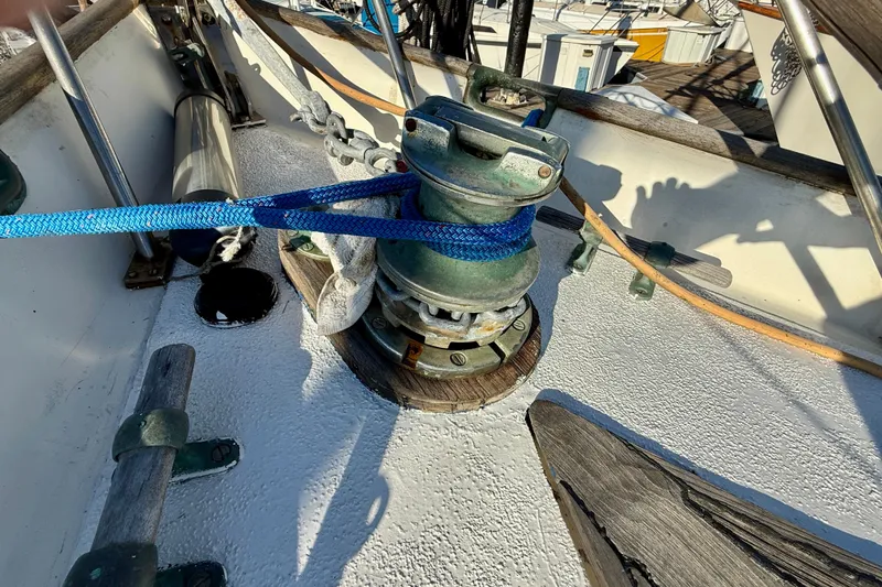 Deck of 1981 Mariner Mayflower sailboat with winch and blue rope.
