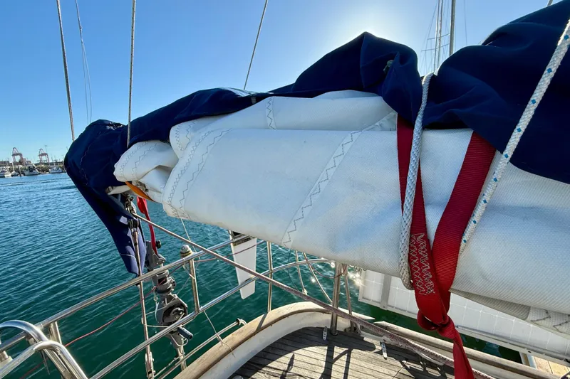 Sailboat deck view, Mariner Mayflower 1981, with sails and rigging against blue sky.