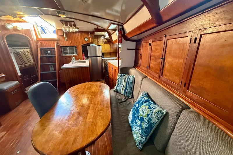 Interior of 1981 Mariner Mayflower yacht with wooden decor and cozy seating area.