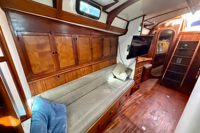 1981 Mariner Mayflower yacht interior with wooden cabinetry, cozy seating, and mounted TV.