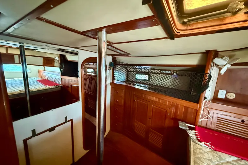 Interior of 1981 Mariner Mayflower boat with wood paneling and cozy sleeping area.