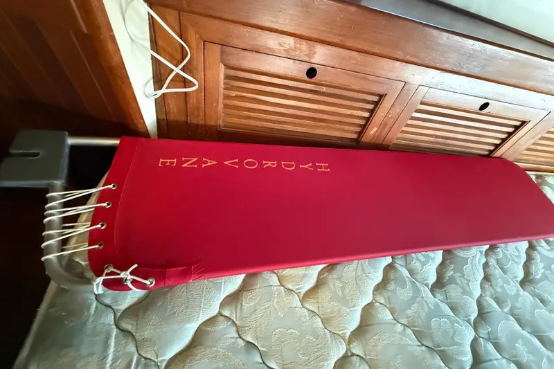 Red padded seat on 1981 Mariner Mayflower boat, wooden interior, nautical design.