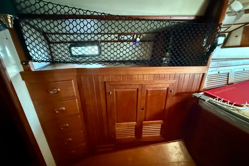 Interior of 1981 Mariner Mayflower boat with wooden cabinets and netting.