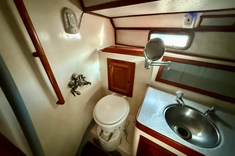 1981 Mariner Mayflower yacht bathroom with toilet, sink, and mirror.