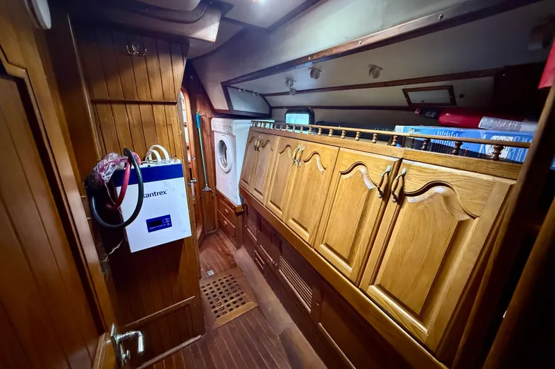 1981 Mariner Mayflower yacht interior with wooden cabinetry and washing machine.