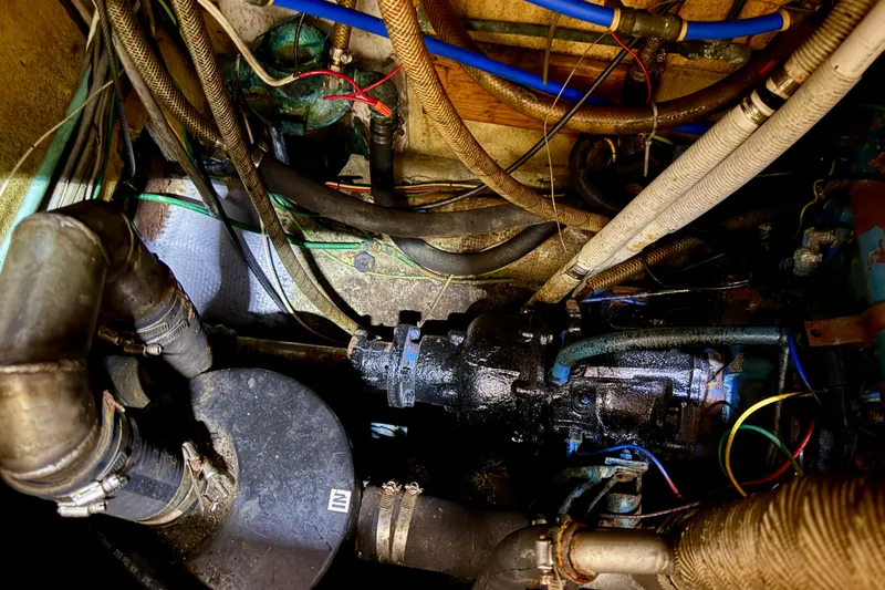 Engine room of 1981 Mariner Mayflower boat with visible pipes and wiring.