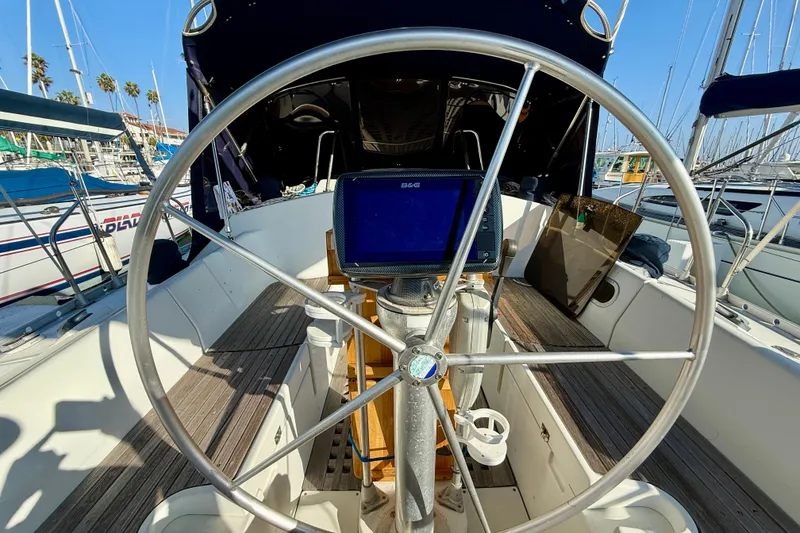 Steering wheel of 1988 Beneteau Oceanis 390 sailboat in marina setting.