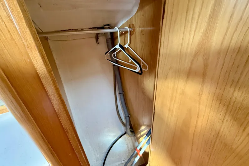 Interior of 1988 Beneteau Oceanis 390 sailboat with wooden paneling and hangers.