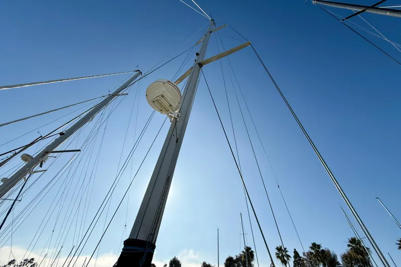 Mast of 1988 Beneteau Oceanis 390 sailboat against clear blue sky.