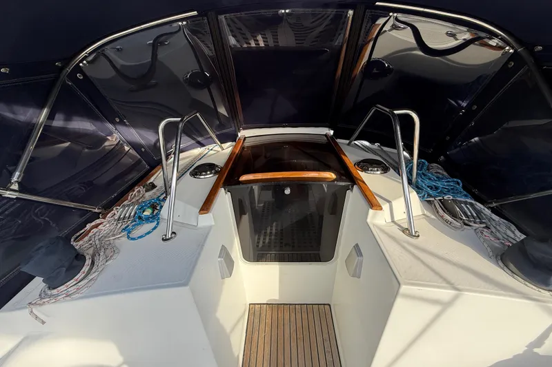Cockpit of 1988 Beneteau Oceanis 390 sailboat with ropes and canopy.