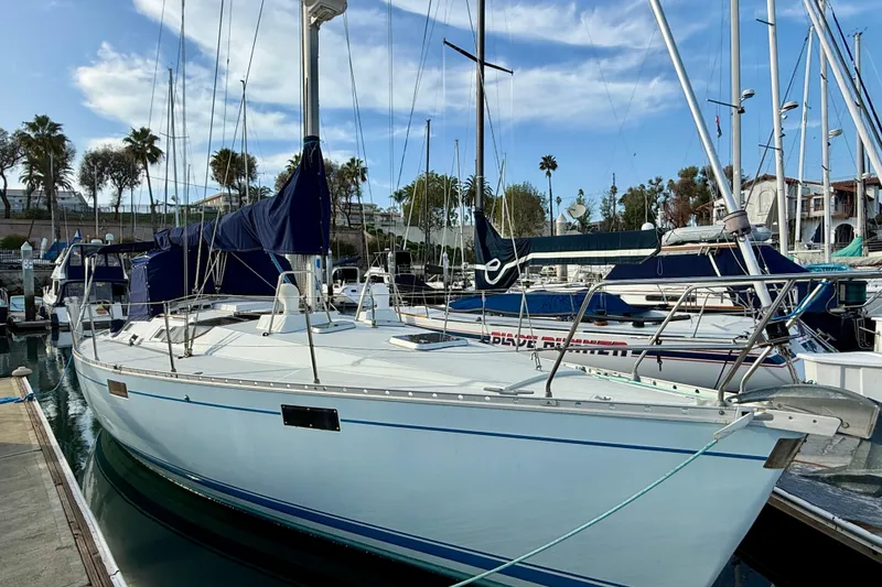 1988 Beneteau Oceanis 390 sailboat docked in a marina with clear skies.
