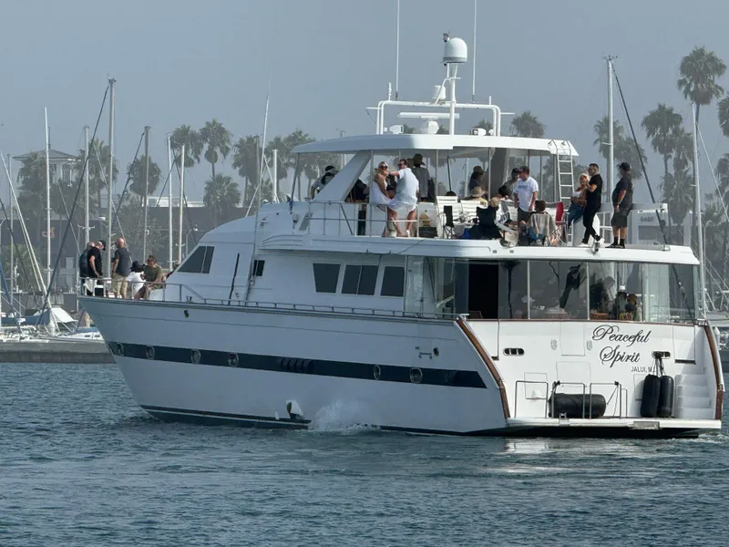 1990 Versilcraft Challenger Motor Yacht cruising with passengers, docked in a marina.