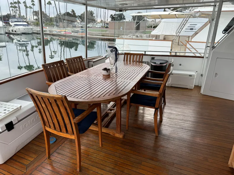 1990 Versilcraft Challenger Motor Yacht deck with wooden dining table and chairs.