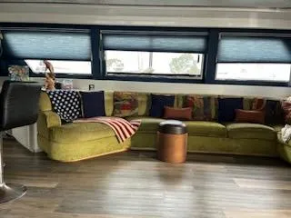 Luxurious 1990 Versilcraft Challenger yacht interior with green sofa and modern decor.