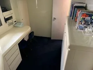 1990 Versilcraft Challenger Motor Yacht interior with desk, chair, and bookshelf.