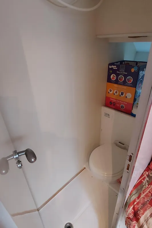 Compact bathroom in 1990 Versilcraft Challenger Motor Yacht with shower and toilet.