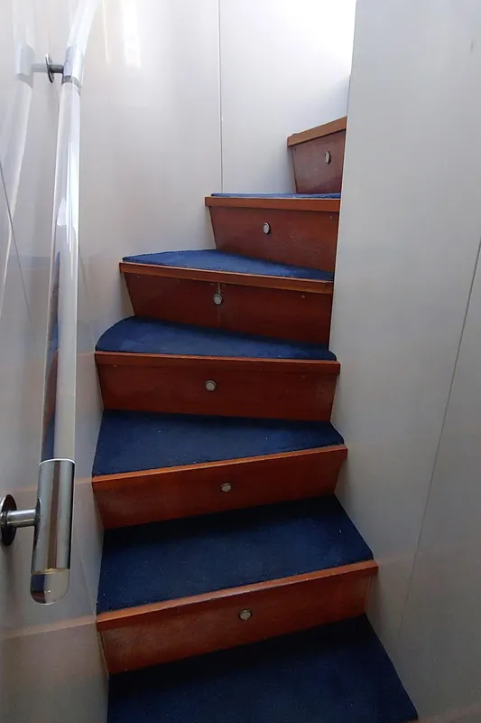 Staircase with blue carpet on 1990 Versilcraft Challenger Motor Yacht.