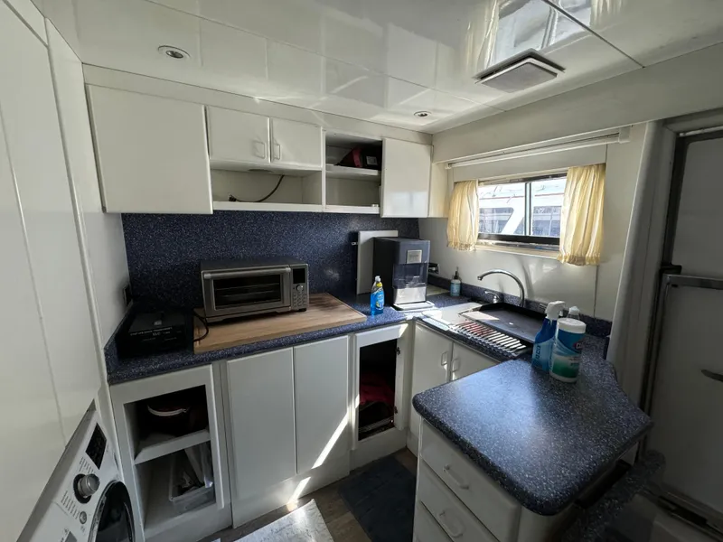 1990 Versilcraft Challenger Motor Yacht kitchen with modern appliances and white cabinetry.