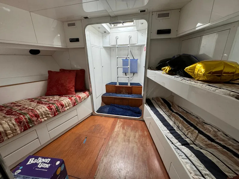 Interior of 1990 Versilcraft Challenger Motor Yacht with cozy bunks and wooden flooring.
