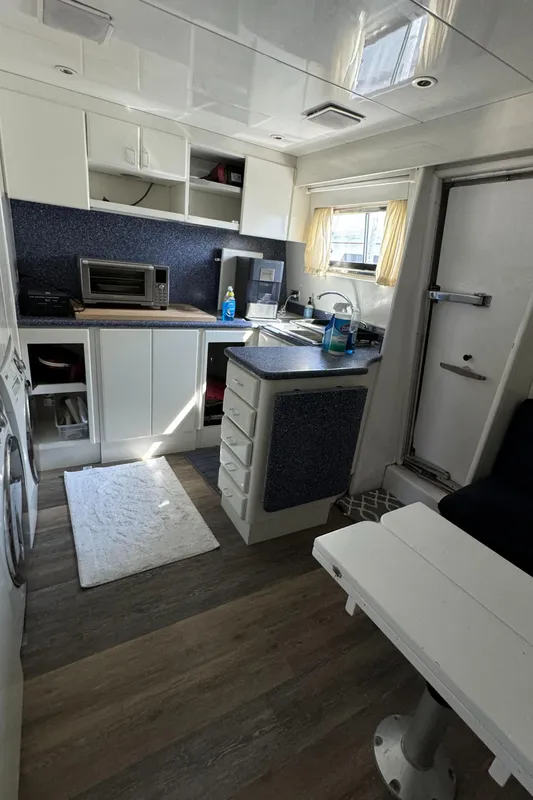 Interior of 1990 Versilcraft Challenger Motor Yacht with modern kitchen and dining area.