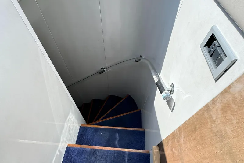 Staircase with blue carpet on 1990 Versilcraft Challenger Motor Yacht.