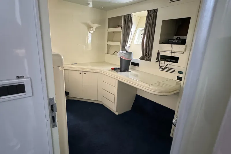 1990 Versilcraft Challenger Motor Yacht interior with desk, TV, and storage cabinets.