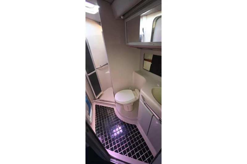 Bathroom interior of 1988 Sea Ray 460 Express Cruiser with modern fixtures and black tile flooring.