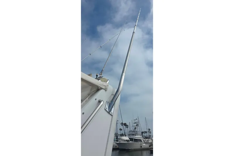 1988 Sea Ray 460 Express Cruiser with fishing rods, docked under a cloudy sky.