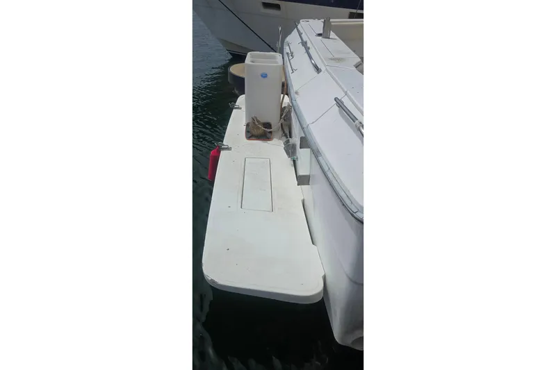 1988 Sea Ray 460 Express Cruiser docked, showing rear deck and water reflection.