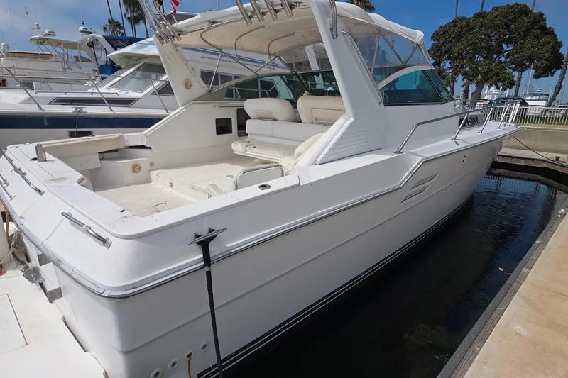 1988 Sea Ray 460 Express Cruiser docked at marina, showcasing sleek white design.