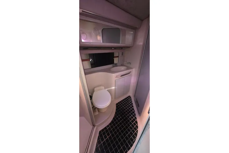1988 Sea Ray 460 Express Cruiser bathroom with toilet, sink, and mirror.