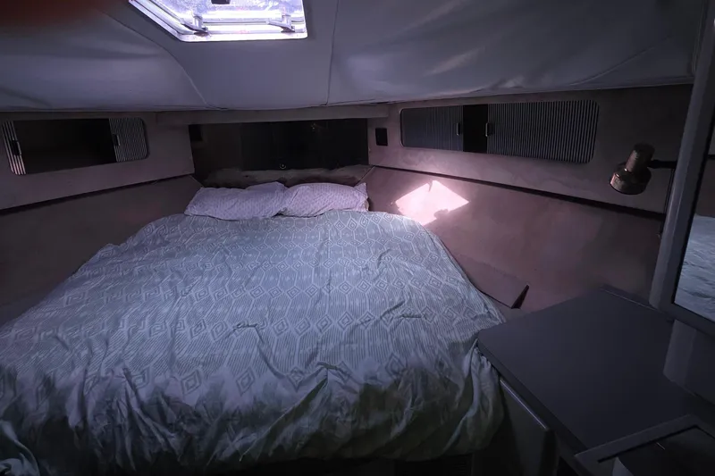 Cozy cabin interior of 1988 Sea Ray 460 Express Cruiser with bed and skylight.