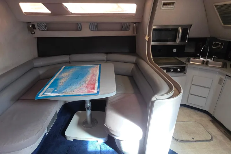 1988 Sea Ray 460 Express Cruiser interior with dining area and kitchenette.