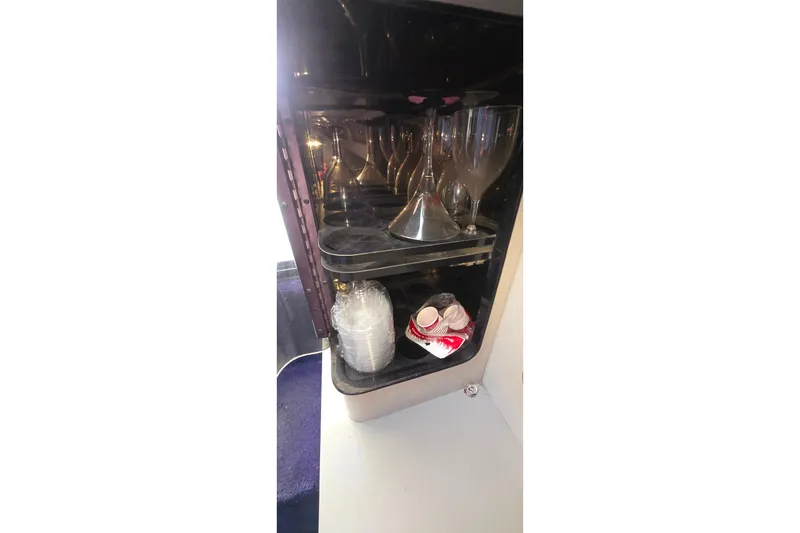 Cabinet with glasses and cups inside a 1988 Sea Ray 460 Express Cruiser.