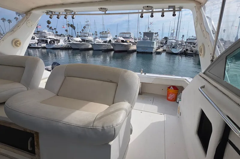 1988 Sea Ray 460 Express Cruiser interior with marina view and docked boats.